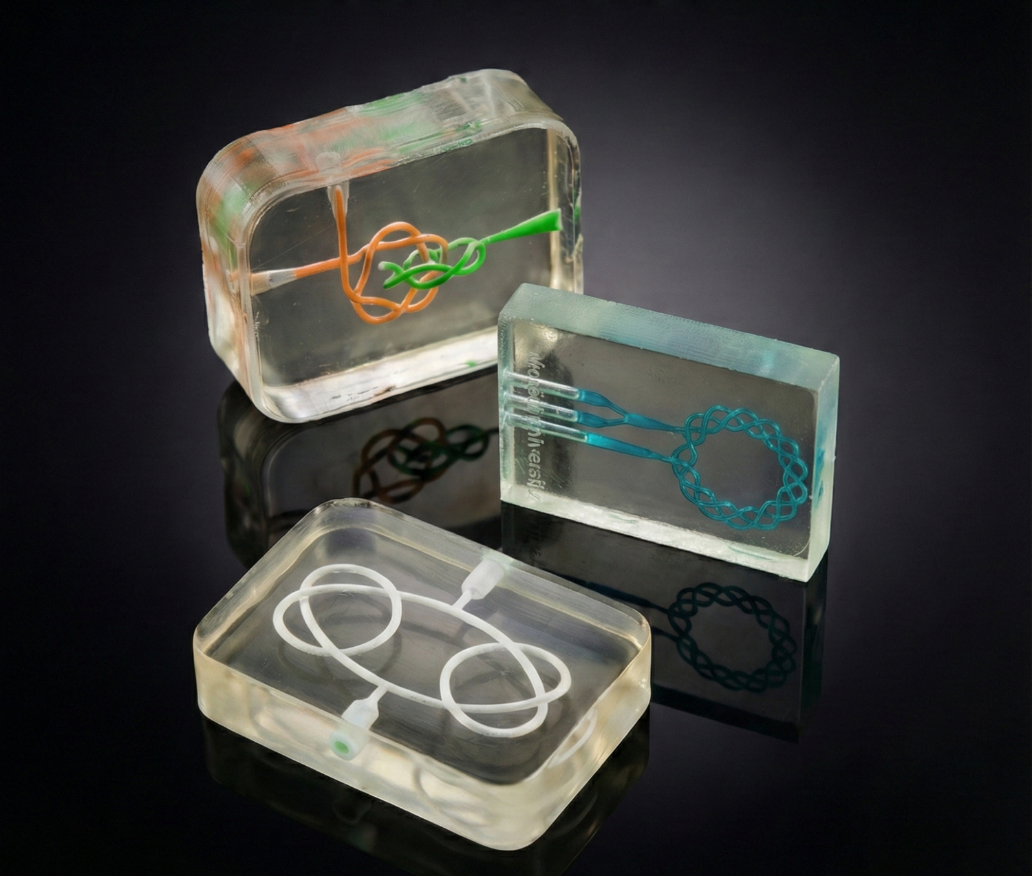 Three transparent microfluidic devices with coloured channels